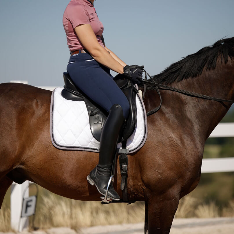 Reiter auf Pferd mit Fokus auf hochgezogene Beine